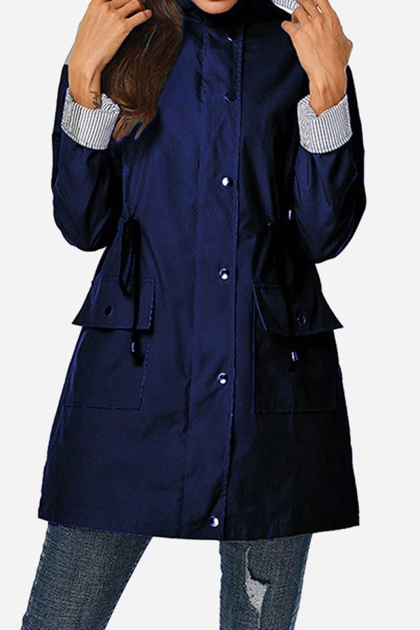 Women's navy hooded water resistant windbreaker jacket with striped cuffs and multiple pockets