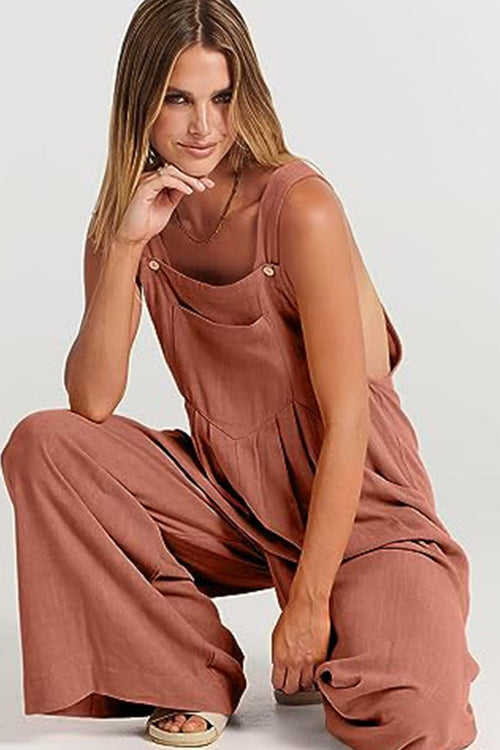 Woman wearing rust-colored Free-Flow Wide Leg Overalls sitting with one knee up