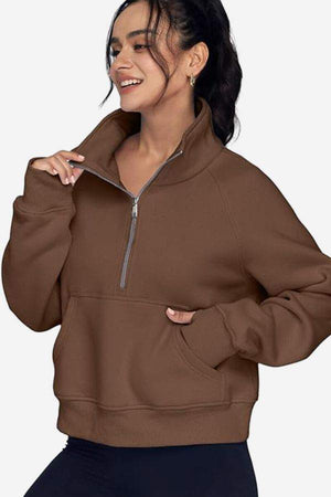 Woman wearing brown cozy oversized half-zip fleece pullover sweatshirt with front pocket