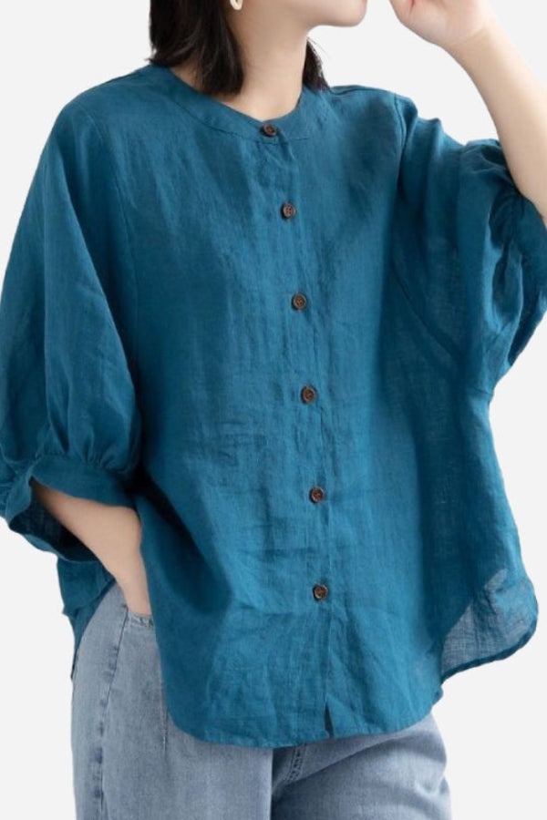 Woman wearing relaxed loose breathable linen button-down blouse in teal color with 3/4 sleeves and casual fit
