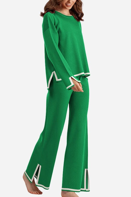 Woman wearing green long sleeved relaxed fit lounge two-piece set with white trim and wide-leg palazzo pants