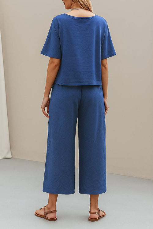 Rear view of model wearing blue loose fit co-ord set with wide-leg trousers and short sleeve top