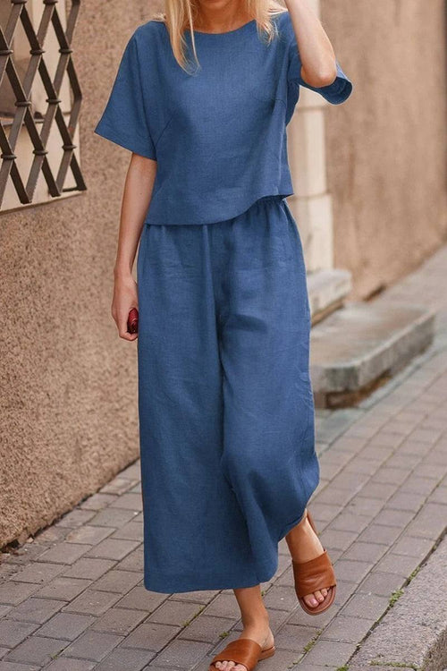 Woman wearing blue loose fit co-ord set with wide-leg pants and short sleeves walking outdoors