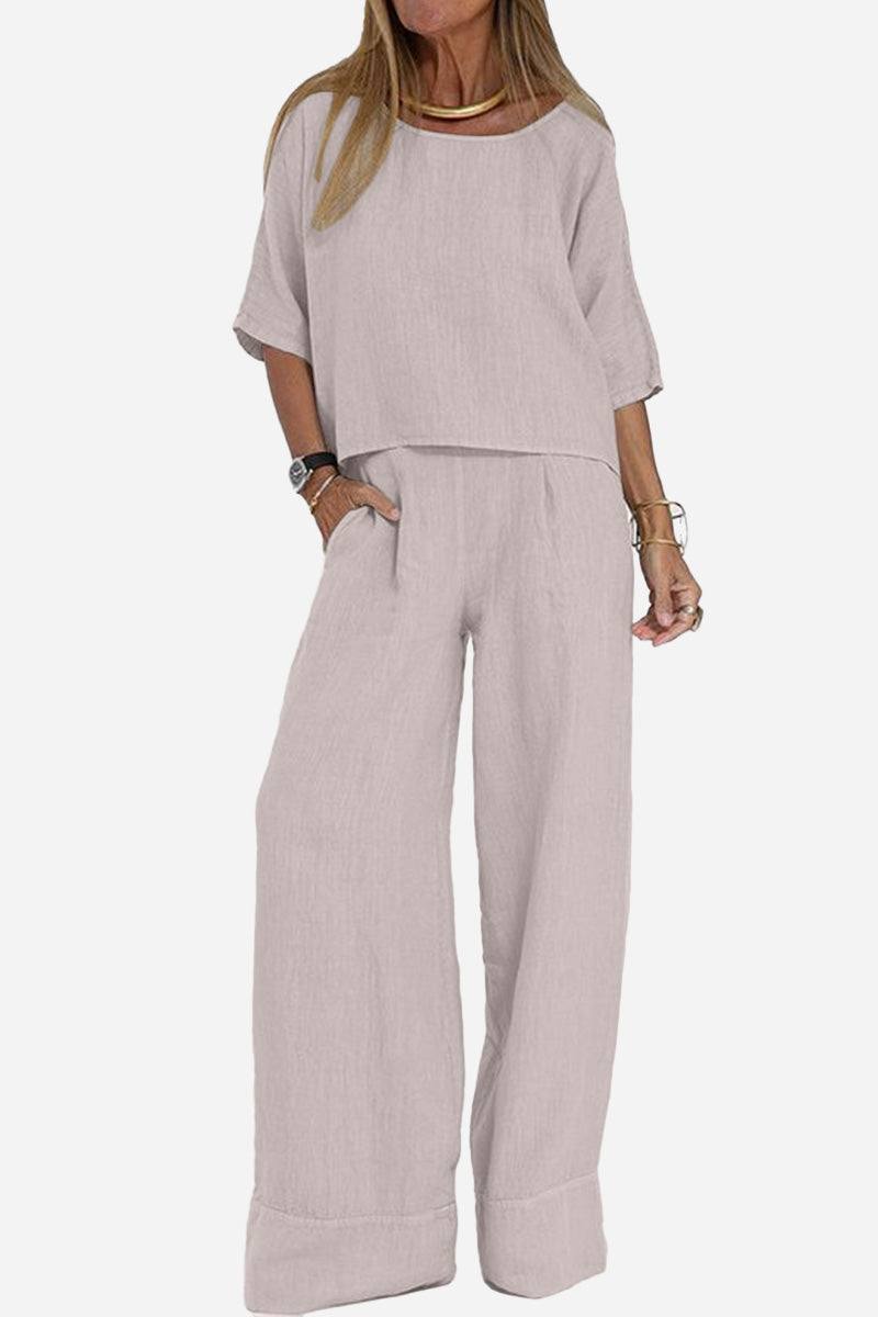 Woman wearing light pink short-sleeved pullover and wide trouser matching set with pockets and cuffed hems
