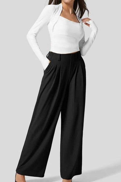 Black high-waisted plicated wide leg waffle pants styled with white fitted long sleeve top