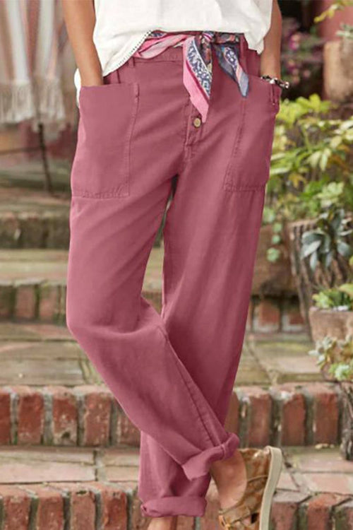 Woman wearing pink casual button-down utility-chic trousers with pockets and rolled cuffs