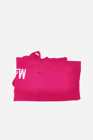 Folded bright pink waterproof travel bag with visible stitched handles and partial white letter print.