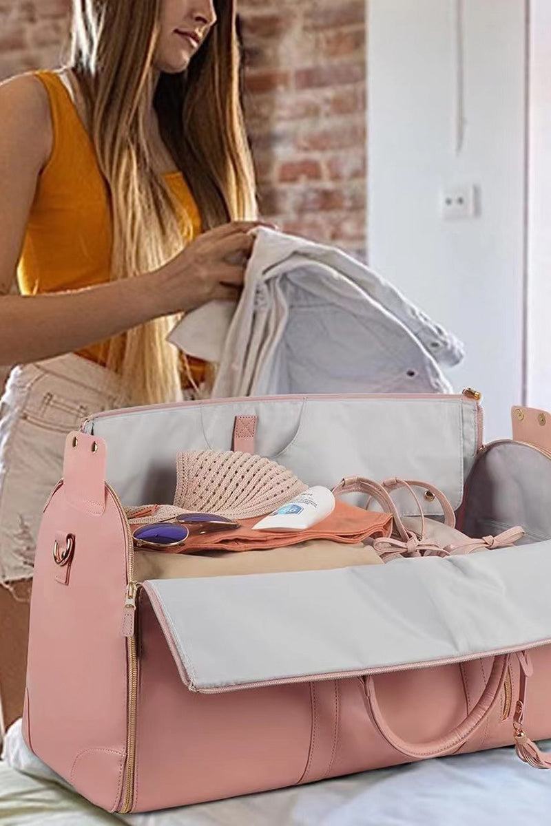 Pink no-wrinkle foldable travel bag open with clothes and personal items inside