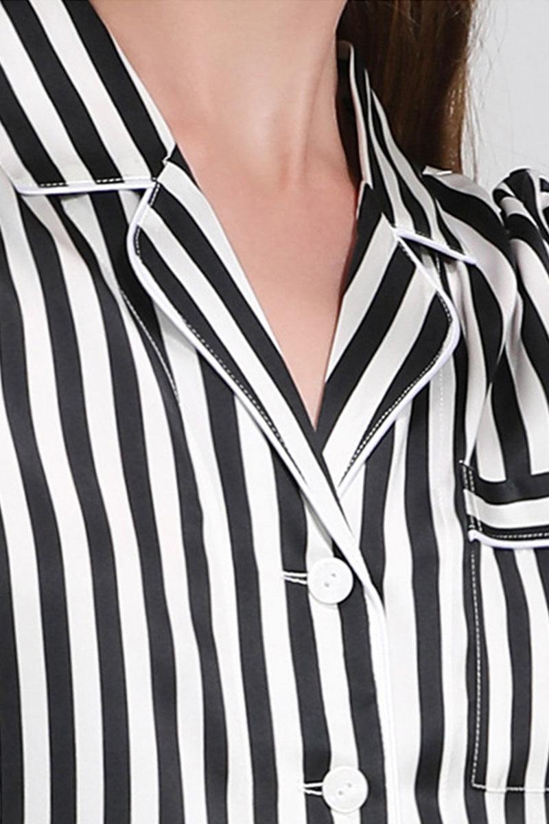 Close-up of 100% Mulberry Silk black and white striped long sleeve pajama top with white buttons and pocket detailing