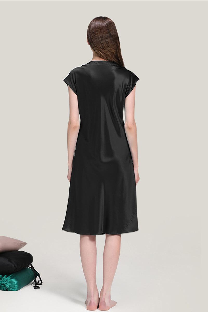 Back view of a woman wearing a black Mulberry Silk V-Neck Nightgown with short sleeves and knee-length hem