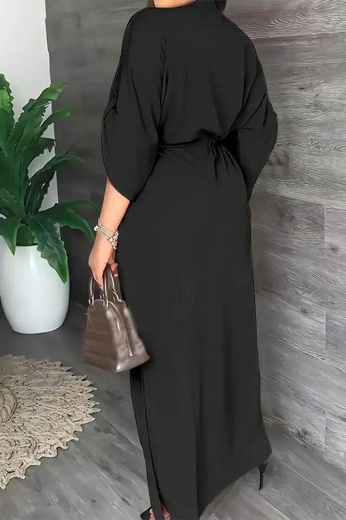Black All-Day Drape Dress with cinched waist and front slit, breathable wrinkle-resistant polyester fabric.