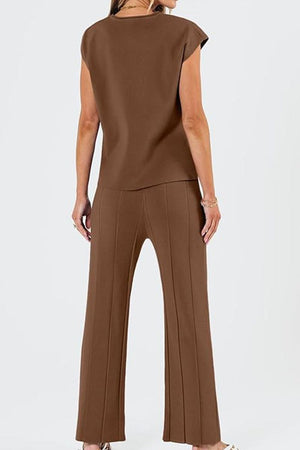 Woman wearing brown First Class Travel two-piece set with pleated wide-leg pants and short sleeve top, back view