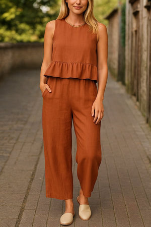 woman wearing rust-colored sleeveless linen-like feel set with wide-leg pants and ruffle top outdoors