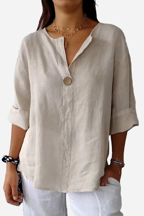 Light beige pure linen age-defying shirt with button detail and 3/4 sleeves, styled with white pants.