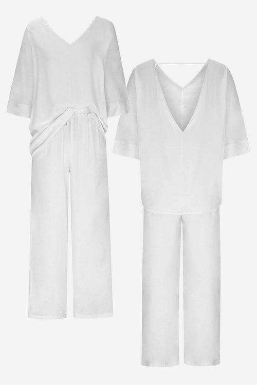 White elegant two-piece pantsuit with V-neck top and tailored wide-leg pants