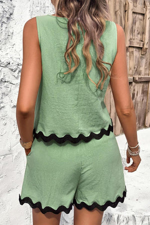 Back view of woman wearing green Flattering Coastal Scallop two-piece set with black scalloped hem