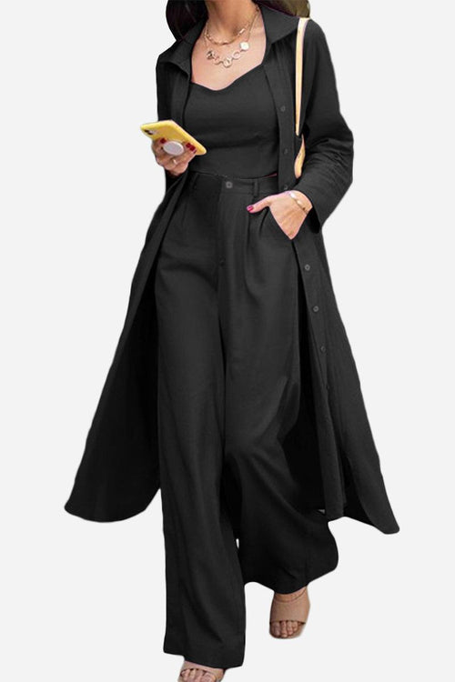 Woman wearing a black relaxed fit shirt and trouser three-piece set with matching long shirt and wide-leg pants.