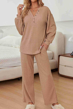 Woman wearing beige Desert Bloom Ribbed Comfort Set with V-neck ribbed top and wide-leg pants in a cozy bedroom.