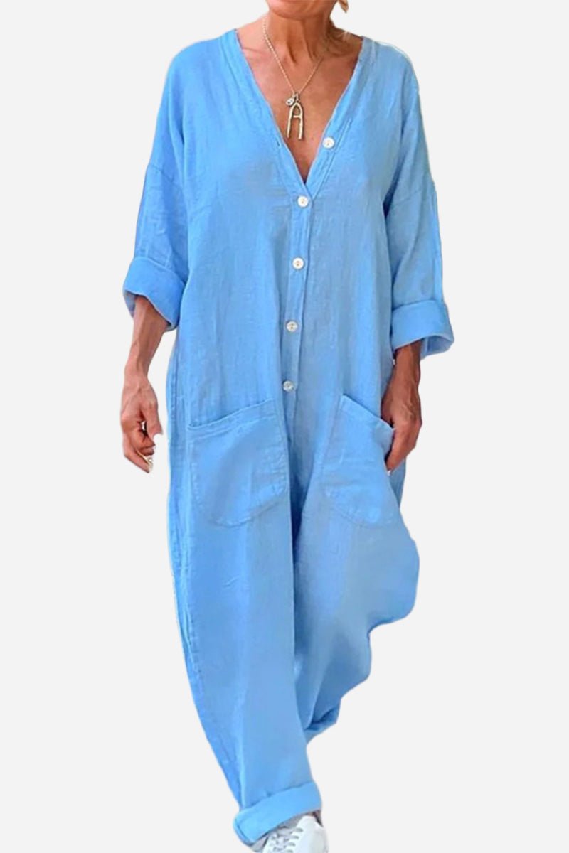 Light blue relaxed jumpsuit with button front, deep V-neckline, rolled sleeves, and front pockets.