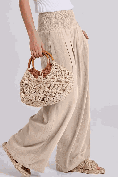 Woman wearing oversized linen blend palazzo pants and holding a woven handbag, part of the Oversized Linen Leaved-IN Set.