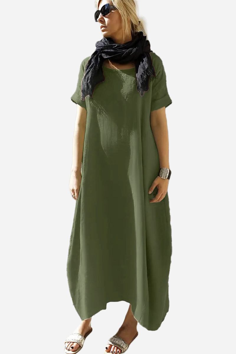 Woman wearing a green Breeze Cocoon Dress with rolled sleeves and a black scarf.