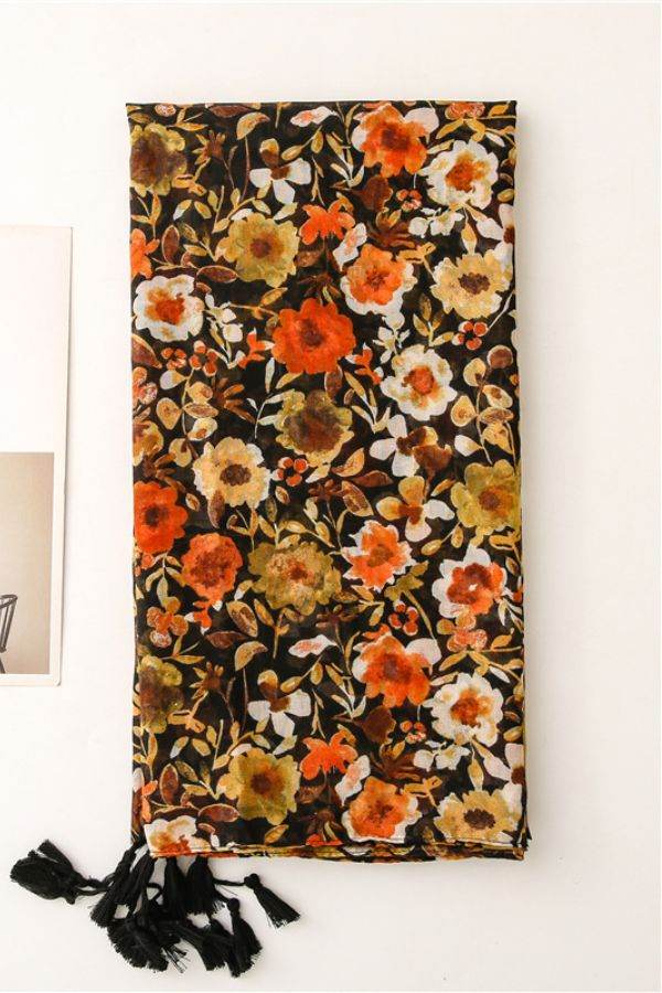 Twilight Blooms Scarf with warm floral print and black tassel edges, lightweight and airy vintage-inspired design