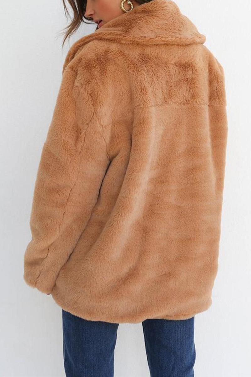 Back view of soft tan open front oversized faux fur jacket with draped collar and relaxed fit worn with jeans
