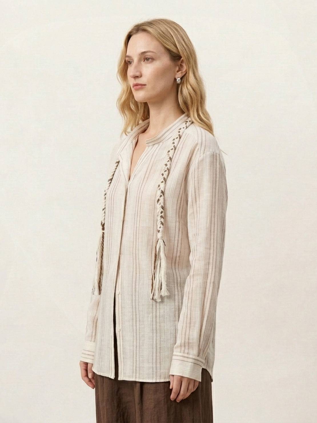 Linen-cotton shirt with vertical stripes, braided tassel trim, drop shoulders, and button cuffs.
