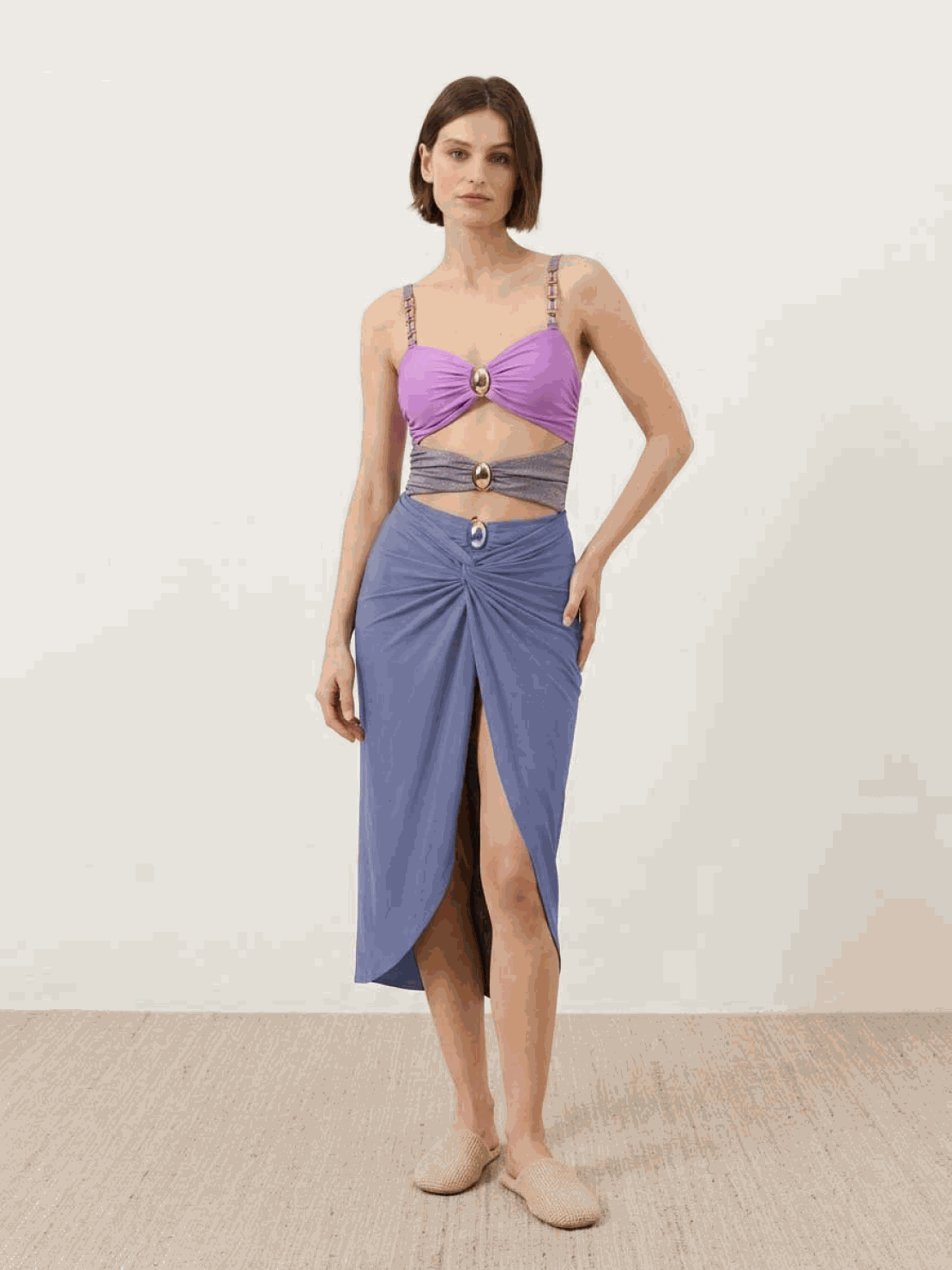 Gold-detail cutout one-piece swimsuit with ruched panels and gold bead straps paired with a midi wrap skirt