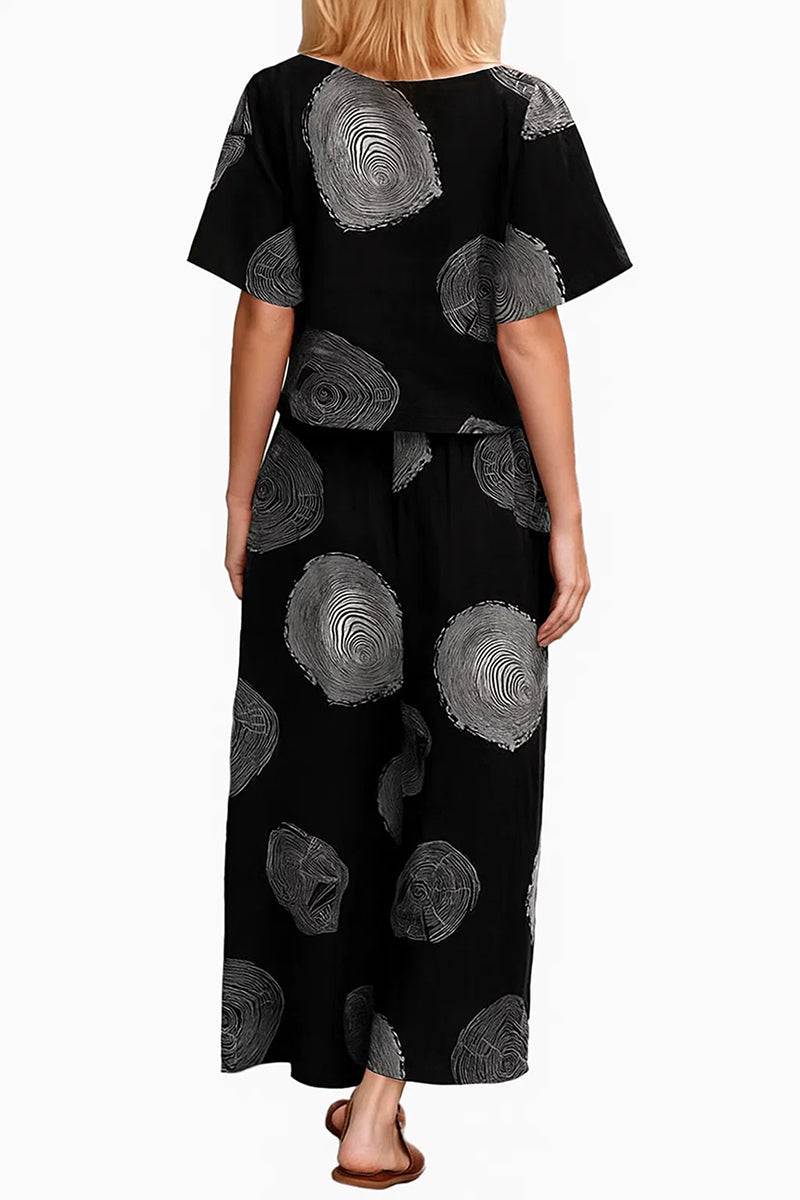 Woman wearing Breezy Meadow two-piece set with relaxed top and wide-leg trousers against white background