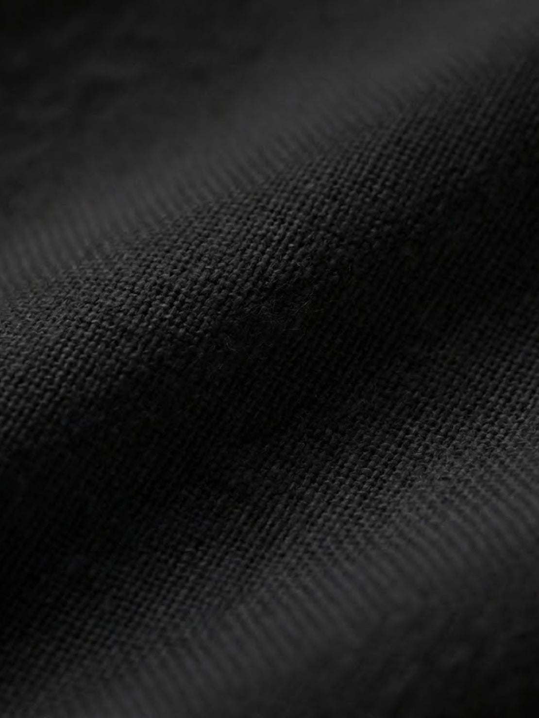 Close-up of black cotton fabric texture for short-sleeved pullover and wide trouser matching set