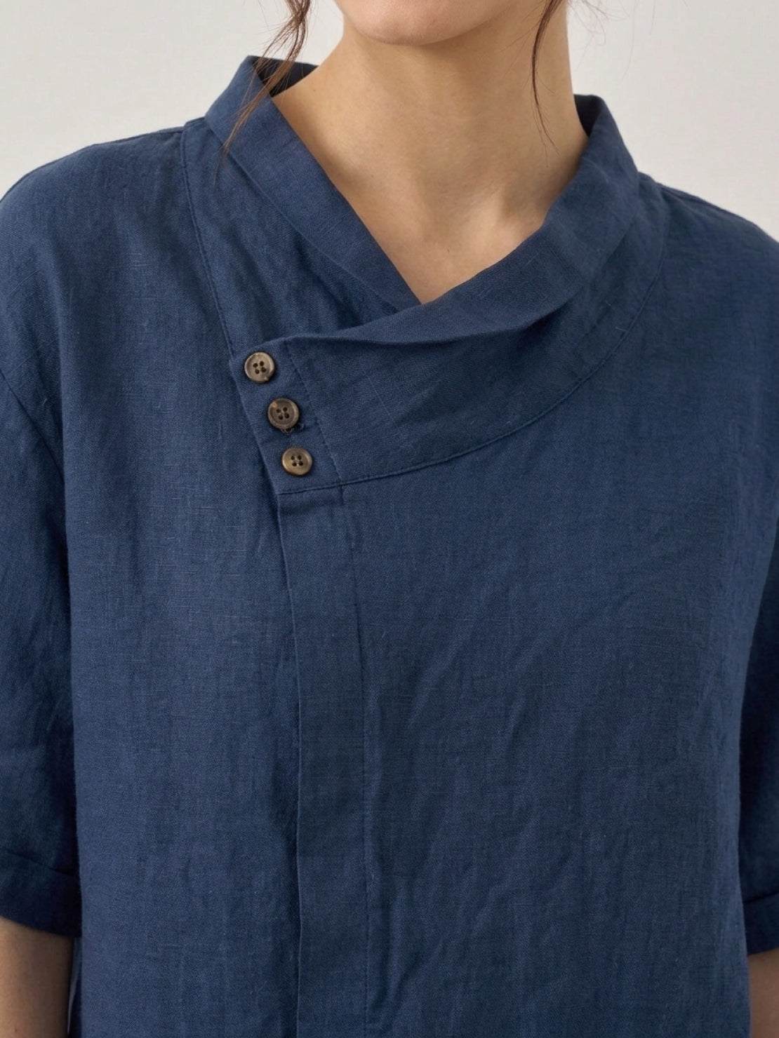 Lightweight 100% linen relaxed V-neck top with asymmetric button design and short sleeves in cream color