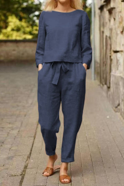 Woman wearing navy blue cotton-linen monochrome capsule outfit with relaxed longline top and wide-leg pants walking outdoors