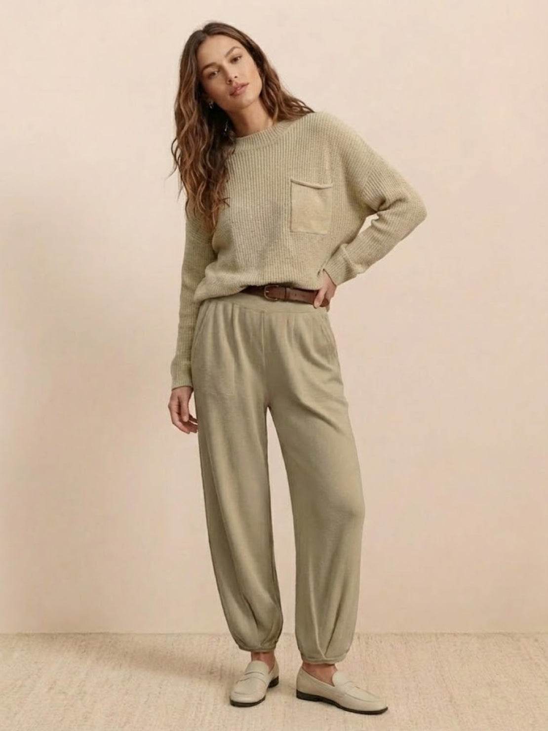Woman wearing European minimalism relaxed khaki sweater top and trouser set with knit pocket and crew neck.