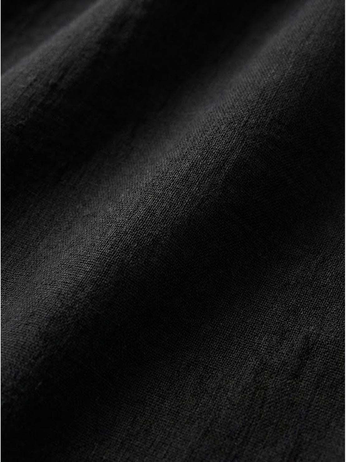 Close-up of black loose solid color fabric with soft, breathable texture