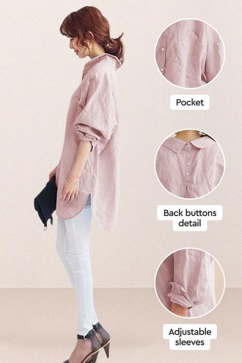 Side view of a woman wearing a pink oversized linen shirt with back buttons, adjustable sleeves, and a pocket, paired with white pants and heels