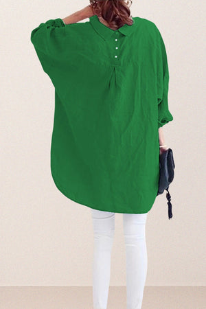 Back view of oversized linen shirt in green with loose sleeves and button details worn with white pants