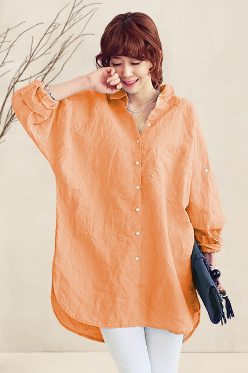 Woman wearing oversized linen shirt in soft orange with relaxed fit and button details