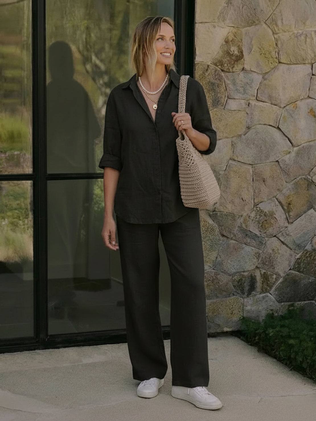 Woman wearing oversized 100% cotton black shirt and wide-leg pants co-ord set standing outdoors