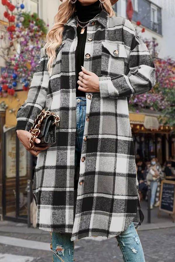 Oversized medium-length blue plaid overshirt with button closure and chest pockets worn over black turtleneck and jeans