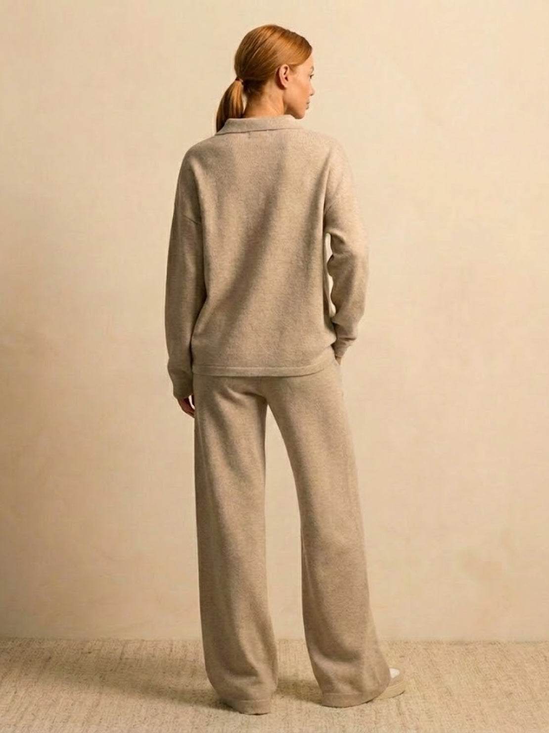 woman wearing plush and preppy camel two-piece set with long sleeves and wide-leg pants standing against beige background