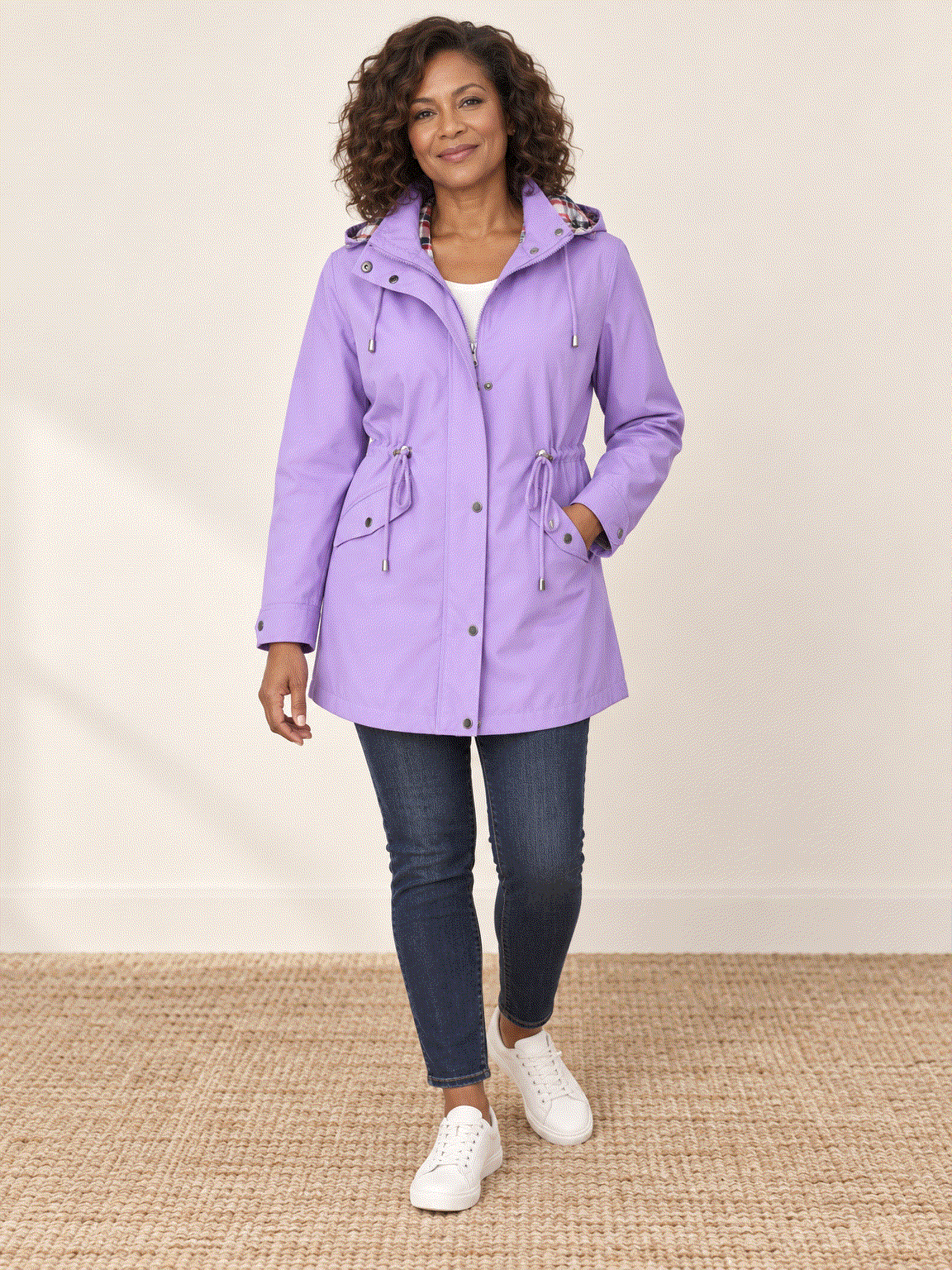 woman wearing plaid-lined hooded rain jacket with waterproof shell and tartan lining outdoors