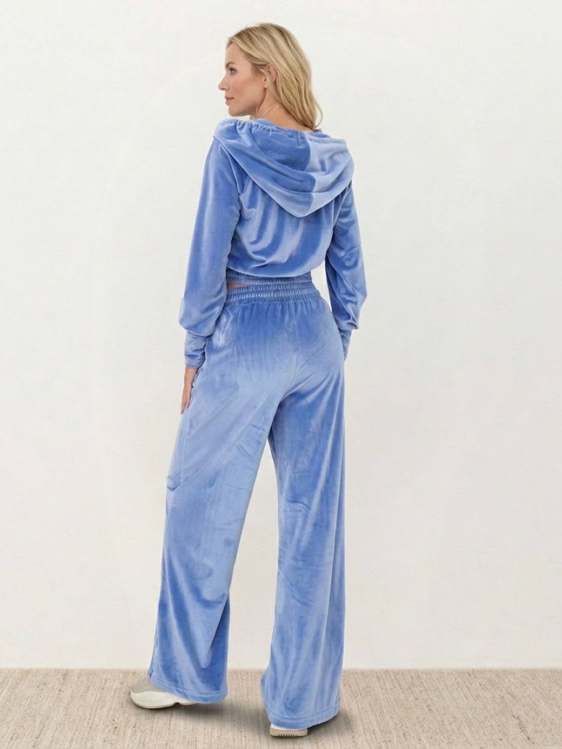 Woman wearing a modern cropped velour tracksuit set with high-waist pants in vibrant color