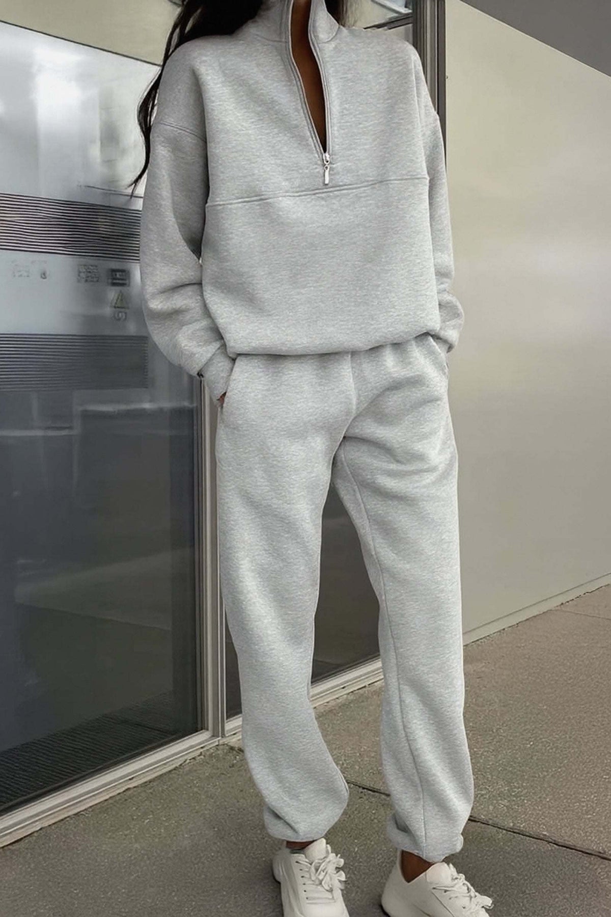 Minimal grey cotton blend tracksuit with zip collar and relaxed fit on model