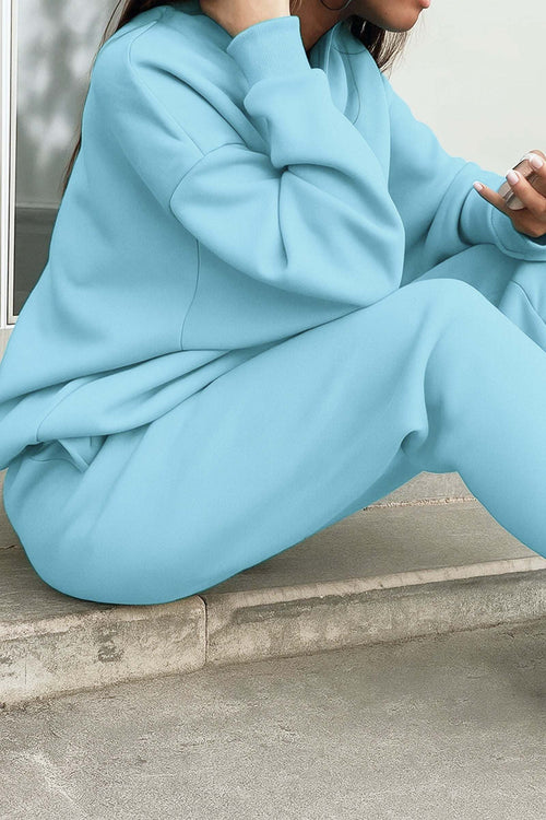 Light blue cotton blend tracksuit with relaxed fit and cropped pullover sitting on concrete steps