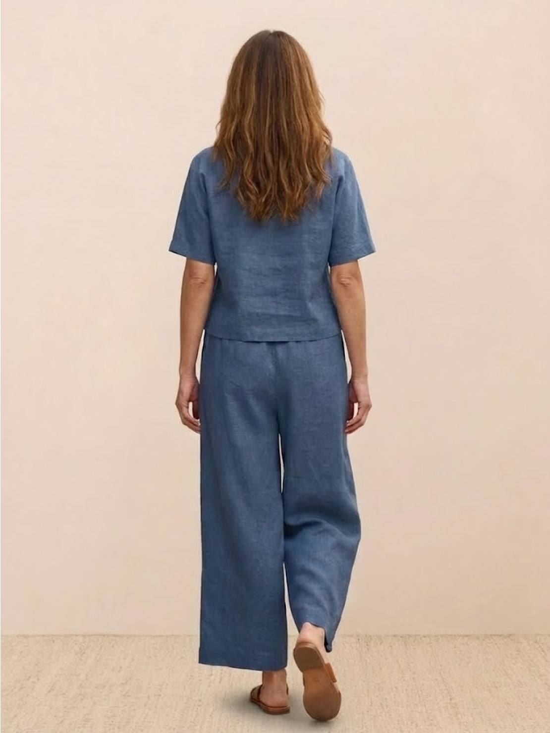 Woman wearing blue loose fit co-ord set with short sleeves and wide-leg trousers back view