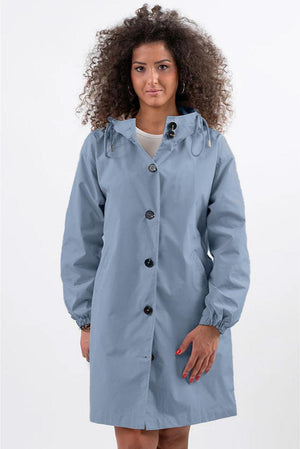 Woman wearing oversized blue Rain Couture Windbreaker jacket with hood and button closure