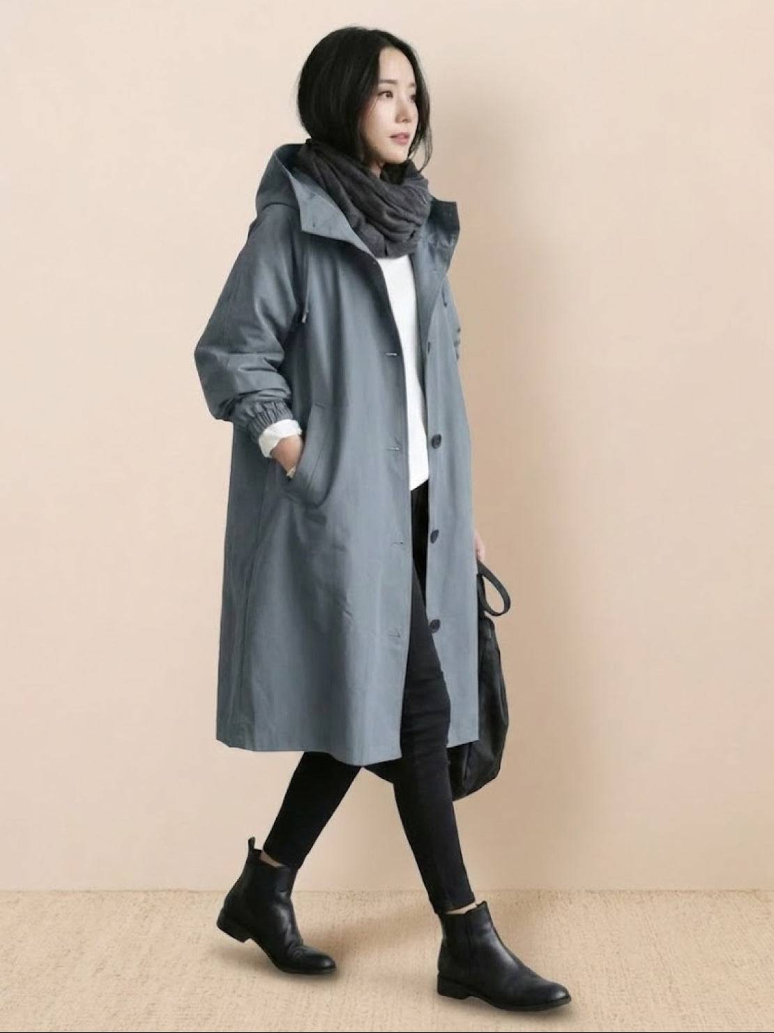 Woman wearing a trendy oversized Rain Couture Windbreaker in gray with black boots and scarf