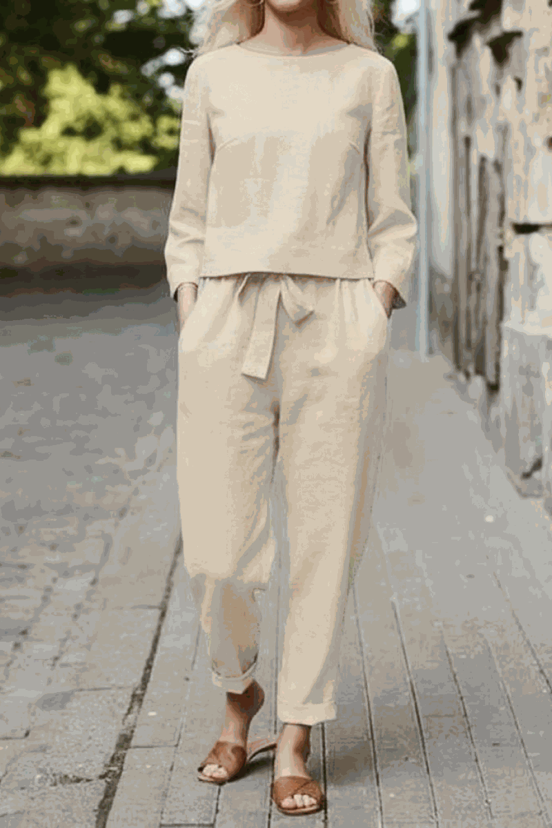 Woman wearing beige cotton-linen monochrome relaxed longline top and wide-leg pants set outdoors