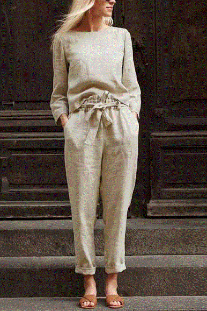 Woman wearing cotton-linen monochrome relaxed longline top and wide-leg pants set in neutral beige color